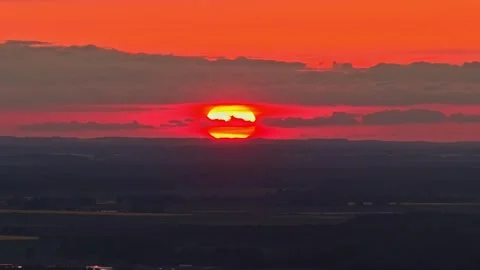 Dramatic red sun setting over a dark silhouetted landscape background Stock Footage 331227785
