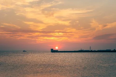 Dramatic red sunset behind the concrete ocean pier in the port of Hel, Poland Stock Photos