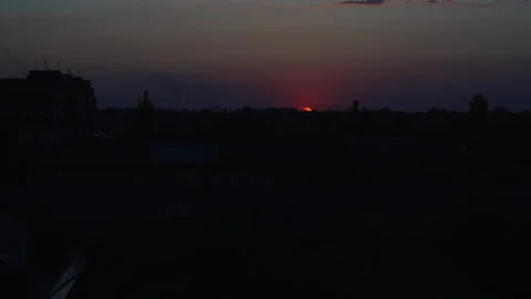 Dramatic Red Sunset Over City Skyline with Water Tower Silhouette Vídeos de archivo 334135042