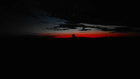 Dramatic Red Sunset Silhouette Over Dark Landscape Vídeo Stock 335659417
