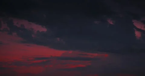 Dramatic red sunset sky featuring heavy dark rain clouds and climate change Stock Footage 341343660