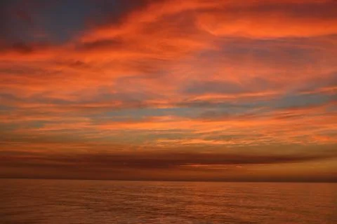 Dramatic red sunset sky over ocean Stock Photos
