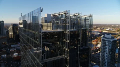 Dramatic reveal of Batman Building framed behind Bridgestone glass wall Stock Footage 122408699