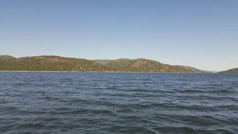 Dramatic reverse drone flight over reservoir with flooded trees and wave motion Stock Footage 309765187