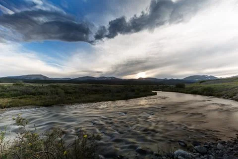 Dramatic river scene under blue sky and vibrant clouds Stock Photos
