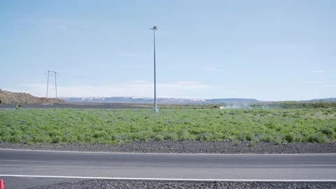 Dramatic roadside view of yellow sedan car smoking tires drifting through Stock Footage 132498855