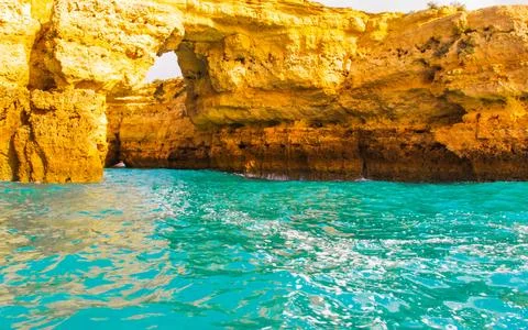 Dramatic rock arch formation carved by sea waves with vibrant turquoise wat.. Stock Photos