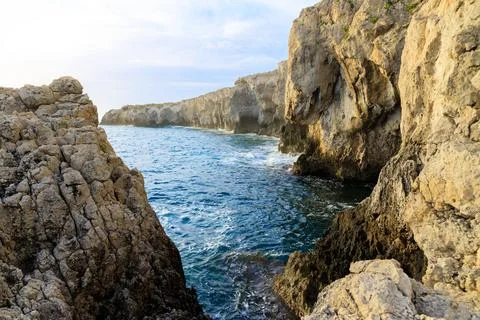 Dramatic rock formations create a natural grotto along a wild coastline bat.. Stock Photos