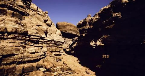 Dramatic rock formations in a narrow canyon under clear blue sky Stock-Illustration