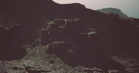 Dramatic rock formations under an overcast sky in a rugged landscape Stock Illustration