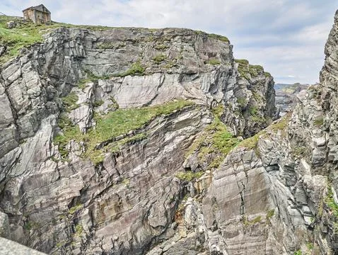 Dramatic rocky cliff landscape with small hut Фото