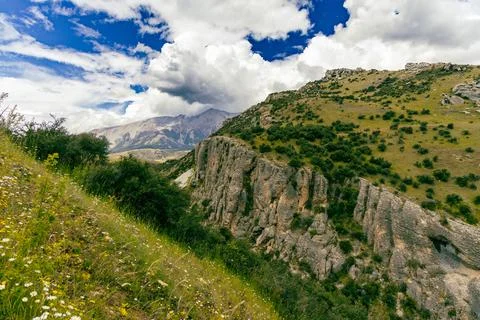 Dramatic Rocky Cliff Under Bright Summer Clouds Foto stock