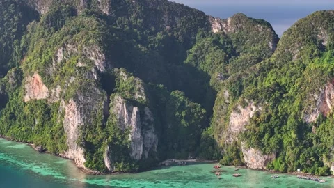 Dramatic rocky cliffs covered in lush green vegetation. Koh Phi Phi Don aerial Video stock 301675369