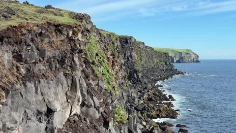 Dramatic rocky coastline and towering sea cliffs of Heimaey island in the Westma Stock Footage 336928526