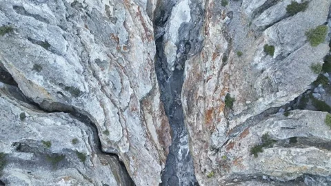 A dramatic rocky gorge funnels the outflow from Kawah Ijen dam, layered stone Stock Footage 329430409