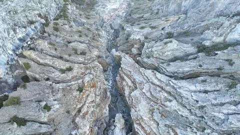 A dramatic rocky gorge funnels the outflow from Kawah Ijen dam, layered stone Foto stock