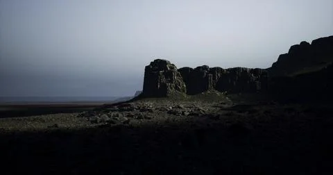 Dramatic rocky landscape under moonlight near coastline at dusk Stock Illustration