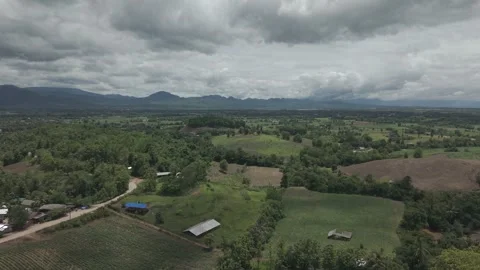 Dramatic Rocky Mountain Peaks and Forested Hills Over Green Farmland, Rainy.. Vídeos de archivo 337390569