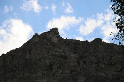 Dramatic Rocky Peak under Blue Skies with Scattered Clouds Stock Photos