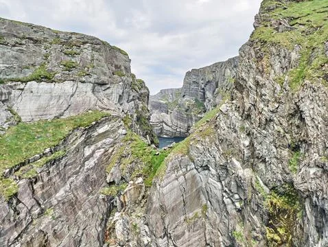 Dramatic rocky sea cliffs with narrow coastal inlet Fotos Stock