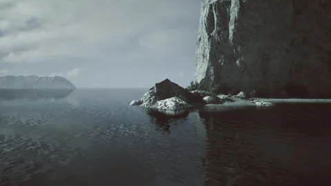 Dramatic rocky shoreline beneath ominous sky with reflective waters Stock Footage 341825964