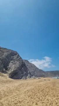 Dramatic sandy beach and rugged cliffs along the Atlantic coast of Portugal 库存照片