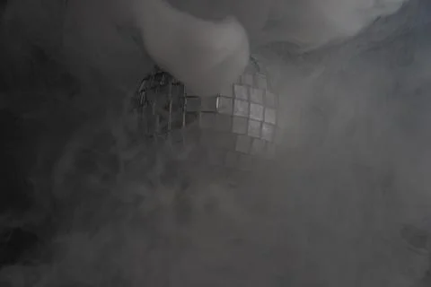 A dramatic scene with a glowing disco ball in a hazy, misty environment, symb Stock Photos