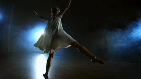 A dramatic scene of modern ballet, a lone ballerina in a white dress performs Stock Footage 120904791