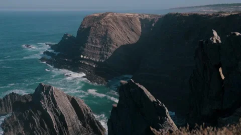 Dramatic sea cliffs and jagged rock pinnacles, Cabo Sardao, Portugal Stock Footage 346479955