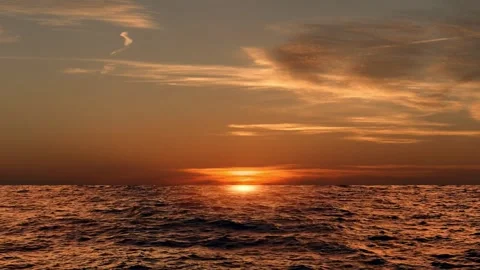 Dramatic sea sunrise Burning sky and shining golden waves 4K Stock Footage 252884626
