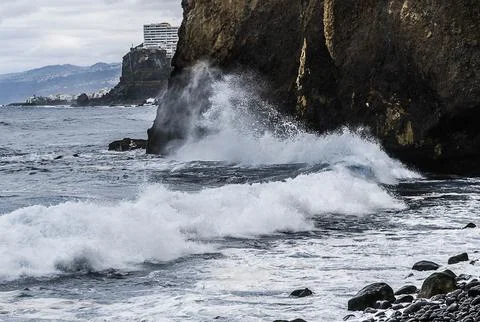 A dramatic seascape featuring powerful waves crashing against a rocky shoreli Stock Photos