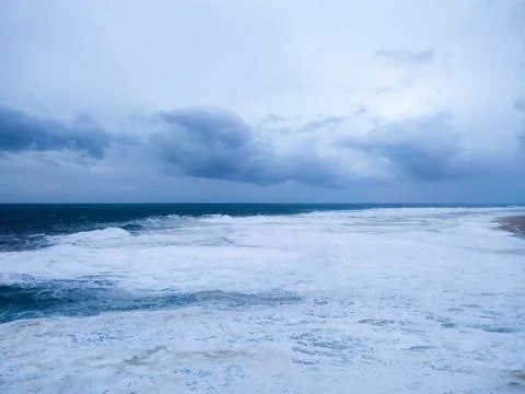 Dramatic seascape featuring turbulent waves under a moody, overcast sky. Ev.. Stock Photos