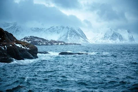 Dramatic Seascape with Snow-Capped Mountains Stock Photos