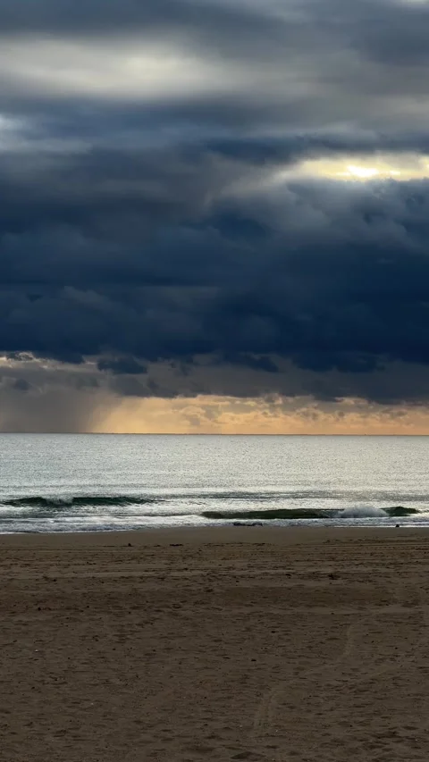 Dramatic seascape with storm clouds over calm ocean at sunset. Vertical Stock Footage 295205660