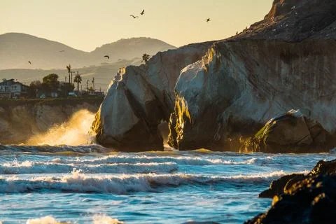 Dramatic seascape. Strong ocean waves hitting  rocks in sunset time at Pism.. Stock-Fotos