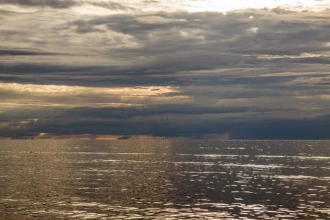 Dramatic seascape with textured clouds and shimmering water. Stock Photos