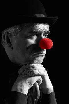 Dramatic selective color portrait of a clown against a dark background lean.. Foto stock