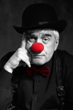 Dramatic selective color portrait of a sad clown against a dark background... Stock Photos