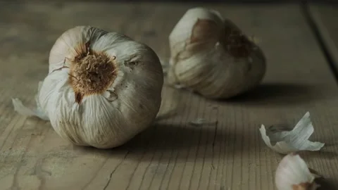 Dramatic shot of garlic on wooden table on daylight Stock Footage 130471692