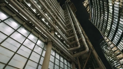 A dramatic shot at night looking up at Lloyds building and the gherkin Stock Footage 297184406