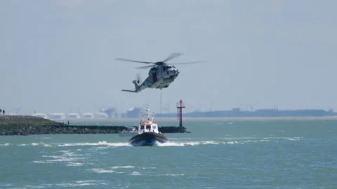Dramatic Shot SAR Helicopter Winching Down Crew Member on Rescue Boat Stock Footage 249306401