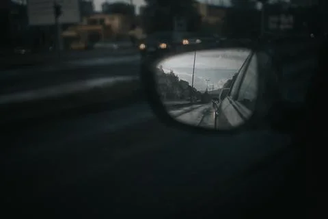 Dramatic shot of the side mirror of a car reflecting the road during the rain Stock Photos