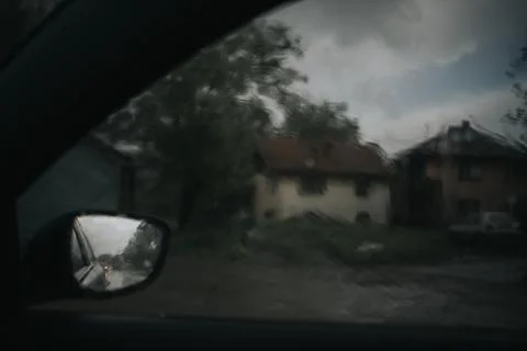 Dramatic shot of the side mirror of a car reflecting the road during the rain Stock Photos