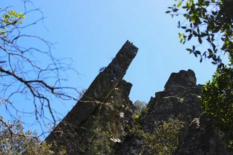 A dramatic shot of a steep, pointed rock formation under a blue sky Stock Photos