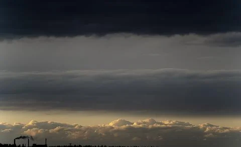 Dramatic shot of three layers of clouds black layer above and a white below crea Foto stock