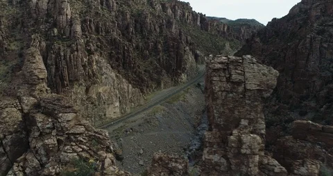 Dramatic shot through tight space in rocks reveals mountain road drone aerial 4K Stock Footage 111312205