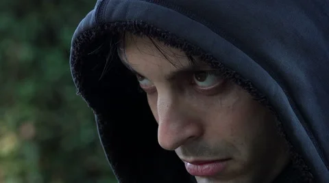 Dramatic side portrait of a young angry man wearing a shirt with a hood Stock Footage 64951412