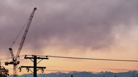 Dramatic silhouette of a construction crane against a vibrant sunset sky Stock Footage 319198358