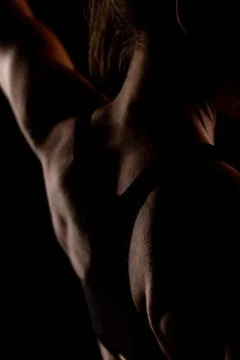 Dramatic Silhouette of a Fit Athletic Back in Low Light Background Stock Photos