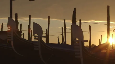 Dramatic silhouette of gondolas, floating in the water at dawn Stock Footage 241273360